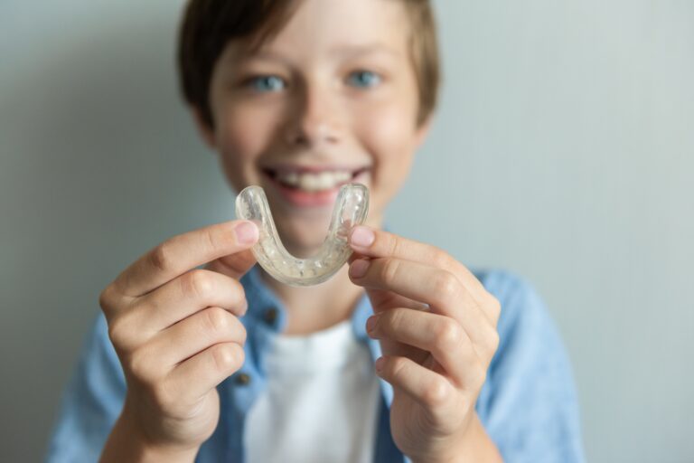 Smiling boy with braces and Invisalign and mouthguard concept. Orthodontic oral care for teenagers